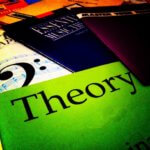 Algunos libros esparcidos en una superficie. Destaca uno con la portada de color verde donde puede leerse la palabra Theory, en referencia al título del artículo, teorías del liderazgo.
