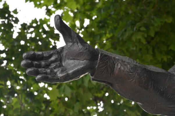 Una mano de bronce, que parece ofrecer su ayuda para resolver los problemas de la humanidad, como haría un buen líder.